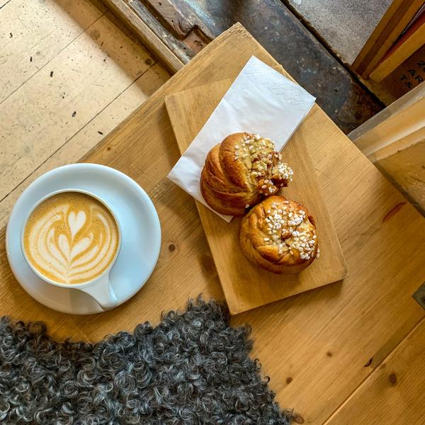 Coffee and two pastries on a wooden board